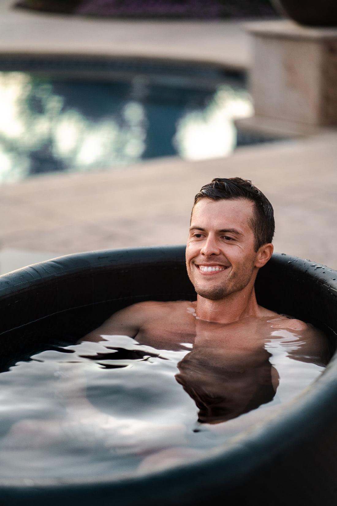 Man immersed in a black Valley Cold Plunges tub